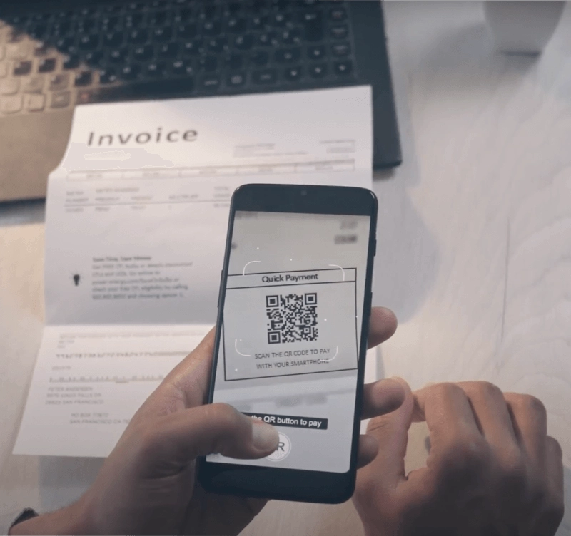 mobile phone scanning a qr code on paper invoice